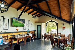 a restaurant with tables and chairs and a tv on the wall at Boutique Hotel Casa Medievala in Curtea de Argeş