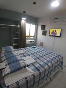 a bedroom with a bed with a blue and white blanket at Smart Residence Flat - FLAT 1009 in Teresina
