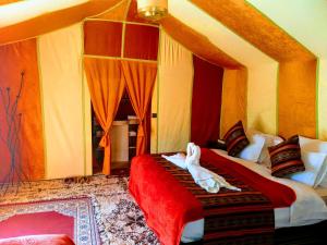a bedroom with two beds with red and yellow walls at Sahara Luxury Desert Camp in Merzouga