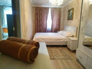 a small bedroom with a bed and a mirror at Площадь in Qyzylorda