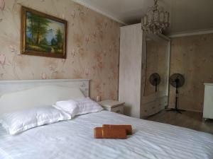 a bedroom with a white bed with a towel on it at Площадь in Qyzylorda +11 photos