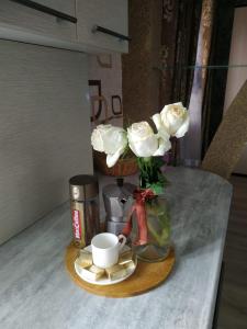 a table with a vase of roses and a cup of coffee at Площадь in Qyzylorda