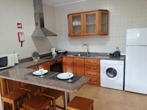 a kitchen with a white refrigerator and a dishwasher at Casa de Ribes T1 Linda Vista in Geres