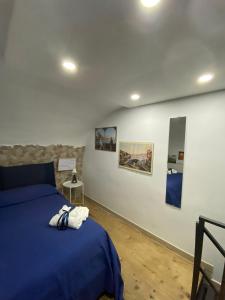 a bedroom with a blue bed and paintings on the wall at Una Notte a Napoli in Naples
