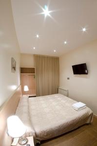 una camera con letto e TV sul soffitto di Hostal Excellence a Barcellona