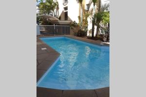 a swimming pool with blue water in a house at Le Topaze Studio in Saint-Pierre