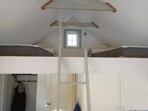 a room with a ladder in a attic with a window at Sjögårdens gästhus med sovloft in Floby