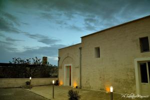 un edificio de ladrillo con dos velas delante en Masseria La Lizza - Ospitalità Rurale, en Lecce
