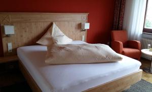 a bedroom with a white bed with a red wall at Hotel & Restaurant Krone in Waldbronn