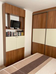 a bedroom with a bed and a tv on a wall at Piano Balaton Apartment in Zamárdi +27 photos