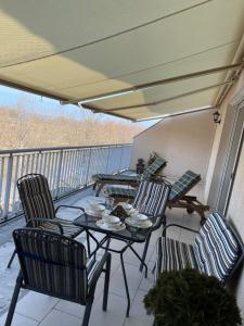 a patio with a table and chairs on a balcony at Piano Balaton Apartment in Zamárdi