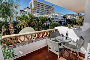 een balkon met een tafel en stoelen en uitzicht op de stad bij TIMON II, Luxury 3 bedroom Beachside Apartment in Benalmádena