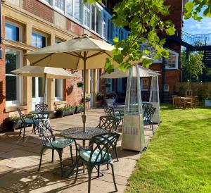 an outdoor patio with tables and chairs and umbrellas at Yarrow Hotel in Broadstairs