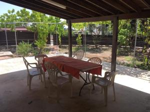 ein Tisch und Stühle mit einem roten Tischtuch drauf in der Unterkunft Friendly villagehouse in Paphos City
