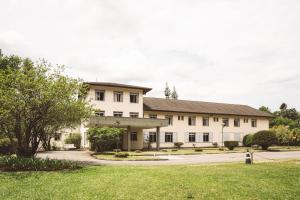 a large white building with a grass yard at Pousada Betânia in Curitiba