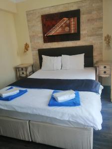 a bedroom with a large bed with blue towels on it at Sığacık Antik Otel in Siğacık