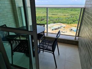 einen Balkon mit einem Tisch und Stühlen sowie Blick auf ein Gebäude in der Unterkunft Salinas Exclusive Resort in Salinópolis