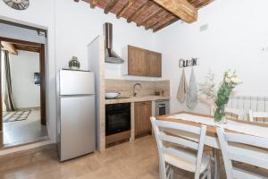 a kitchen with a refrigerator and a table with chairs at Il Mercato - Appartamento con vista in Sinalunga