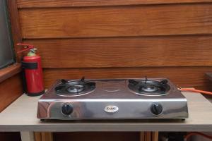 a gas stove sitting on a table next to a fire extinguisher at Kamma-Otter in Natureʼs Valley