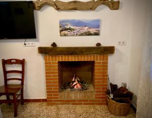 a brick fireplace with a fire in it at Casa Rural Sierra Tórtola 1 in Hinojales