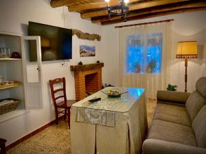 Casa Rural Sierra Tórtola 1 في Hinojales: غرفة معيشة مع أريكة وطاولة
