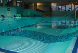 a large swimming pool with blue water at Ferienwohnung mit extra Schlafzimmer und Blick in den Bayrischen Wald oberhalb von Sankt Engelmar in Sankt Englmar +13 photos