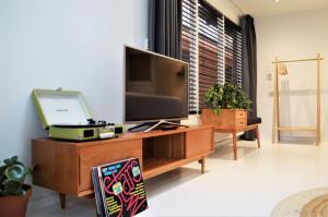 un salon avec une télévision sur un meuble en bois dans l'établissement The Sunset Apartments, à Hollum