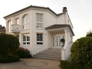 Casa blanca grande con escaleras y porche en Ferienwohnungen Damm, en Kassel