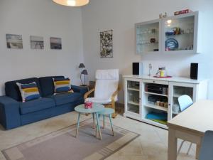 sala de estar con sofá azul y mesa en Villa Mitoyenne Pour 4 Personnes Proche Centre-Ville D hossegor, en Hossegor