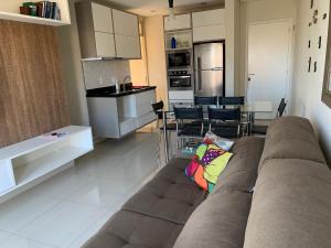 a living room with a couch and a kitchen at Apartamento Decorado in Guarujá