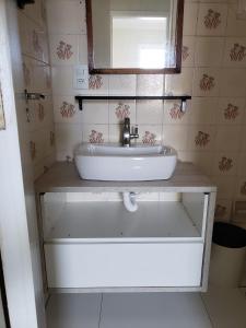 a bathroom with a sink and a mirror at Apartamento Decorado in Guarujá