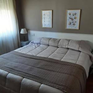 a large bed in a bedroom with a white bedspread at Casa Garay 602 in Mar del Plata