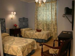 um quarto de hotel com duas camas e uma janela em Hostal Emilia em Trujillo
