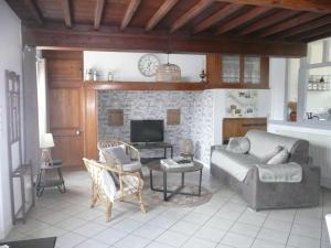 sala de estar con sofá y chimenea en Gîte Liralou Baie de Somme, en Le Titre