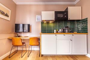 uma cozinha com armários brancos e uma parede de azulejos verdes em Luxury Suites Boutique em Antuérpia