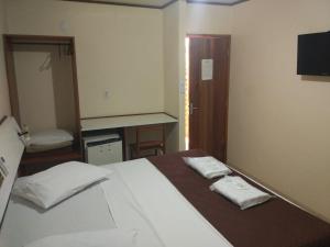 a bedroom with a bed with two towels on it at Hotel Urubupunga in Ilha Solteira