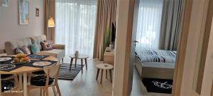 salon i sypialnia z łóżkiem i stołem w obiekcie Apartament Morski - Olimpijska 2, Mielno w mieście Mielno