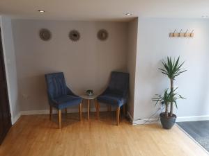 two blue chairs and a table in a room at High gables Apartment 1 in Paignton