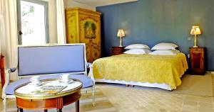a bedroom with a bed and a table and a tv at La Royante in Aubagne