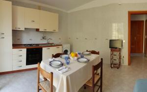 uma cozinha com uma mesa com uma toalha de mesa branca em Marea Retreat Apartments em Marina di Camerota