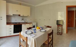 een keuken met een tafel met een witte tafeldoek erop bij Marea Retreat Apartments in Marina di Camerota +28 foto's