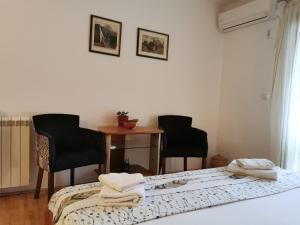 a bedroom with two chairs and a bed and a table at Guesthouse Vukasevic in Virpazar