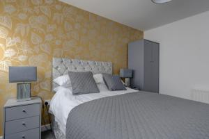 a bedroom with a large bed with a yellow wall at Sunderland Self Catering 4 - City Centre Townhouse with free parking in Sunderland