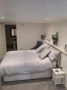 a bedroom with a large white bed with pillows at High gables Apartment 1 in Paignton