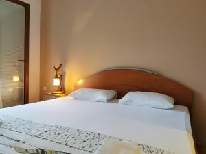 a bedroom with a large white bed with two pillows at Guesthouse Vukasevic in Virpazar
