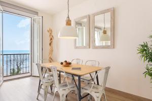 comedor con mesa, sillas y ventana en Sitges Group Beach Dreams, en Sitges