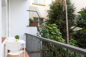 balcón con mesa blanca, sillas y plantas en Sitges Group Beach Dreams, en Sitges