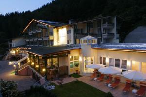 eine Luftansicht eines Hotels mit Tischen und Sonnenschirmen in der Unterkunft Alpenhotel Fischer 4 Sterne - Adults Only in Berchtesgaden