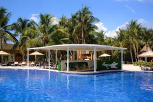 un complexe avec une piscine et des palmiers dans l'établissement Catalonia Playa Maroma - All Inclusive, à Playa del Carmen