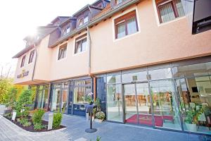 ein großes Backsteingebäude mit Glasfenstern auf einer Straße in der Unterkunft Hotel Krone OHG in Gerlingen